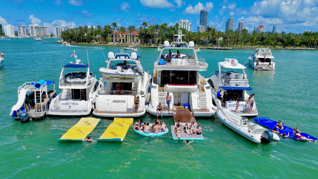 Fleet of yachts gathered on turquoise water with the Miami skyline