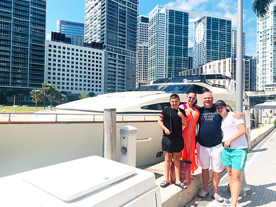 Guests posing with a yacht and Miami skyline behind them